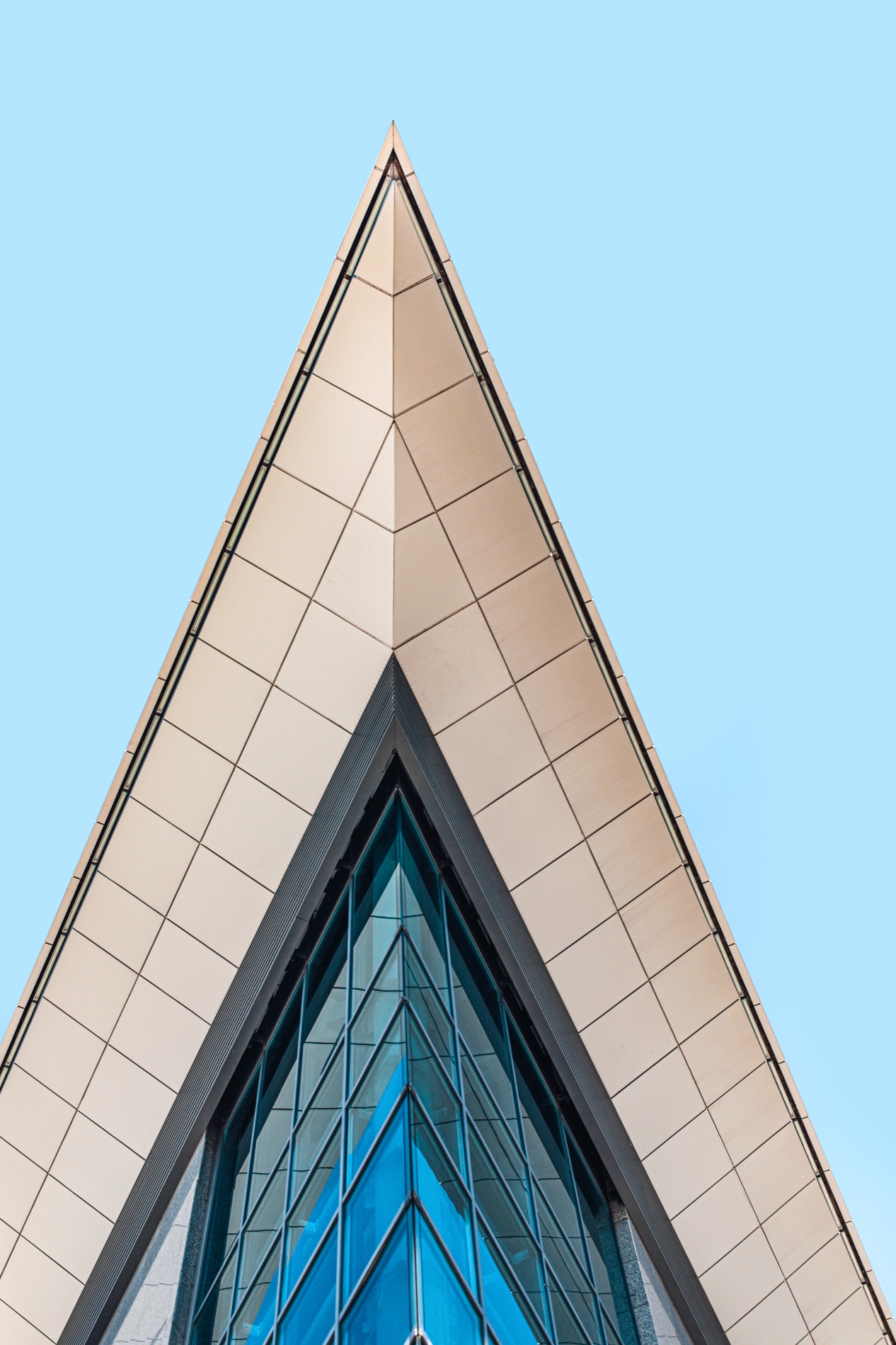 The glazed peak of a high-rise building against the sky